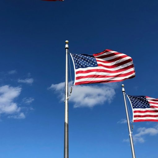 U.S. American flags under clear sky, illustrating American leadership in cloud computing