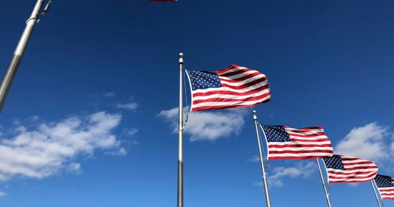 U.S. American flags under clear sky, illustrating American leadership in cloud computing