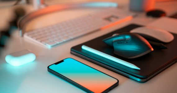 A laptop, mouse, and cell phone on a desk, illustrating what virtualization lets you do
