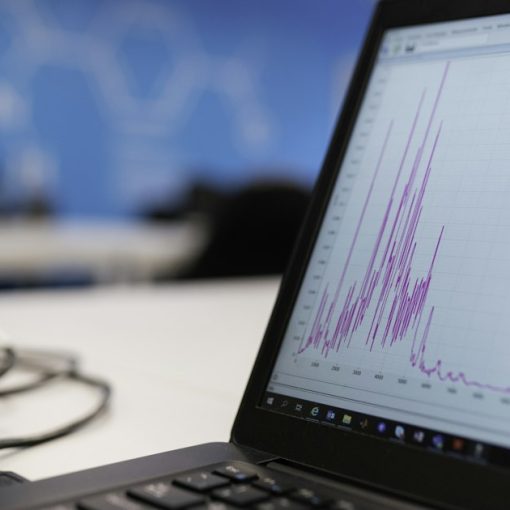 Laptop on a wooden desk displaying data charts, illustrating analysis of 2018 cloud computing trends