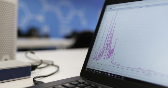 Laptop on a wooden desk displaying data charts, illustrating analysis of 2018 cloud computing trends