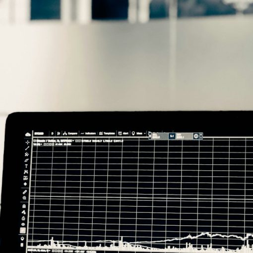 A computer screen displaying a white line graph of financial market data, illustrating big data and legal risk