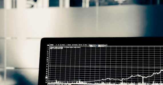 A computer screen displaying a white line graph of financial market data, illustrating big data and legal risk
