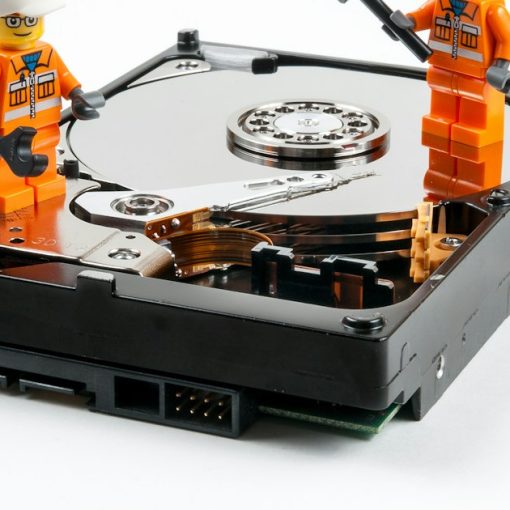 A couple of legos standing next to a hard drive, illustrating big data growth