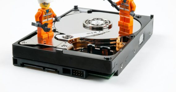 A couple of legos standing next to a hard drive, illustrating big data growth