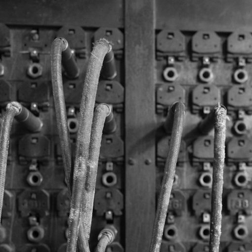 Old telephone switchboard with many wires, illustrating botnets attacking VoIP