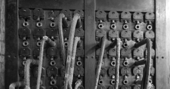Old telephone switchboard with many wires, illustrating botnets attacking VoIP
