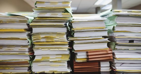 Stacks of paper documents and file folders, illustrating protecting business data from leaks