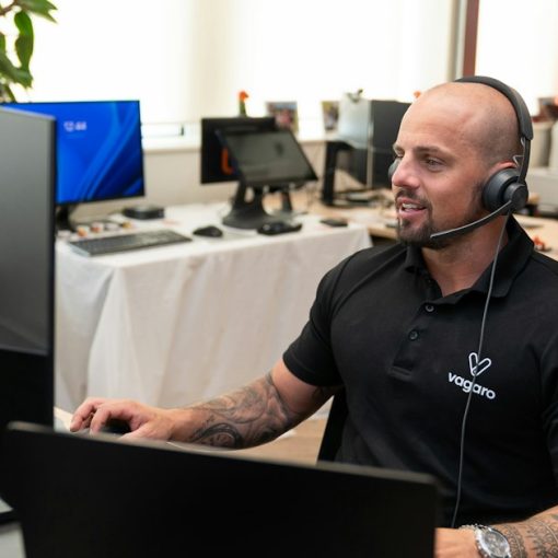 A man wearing a headset in front of a computer, illustrating cloud and big data benefits for BPO