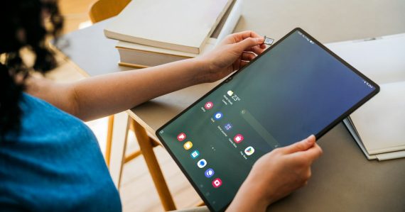 A woman sitting at a table with a tablet, illustrating BYOD tools for the enterprise