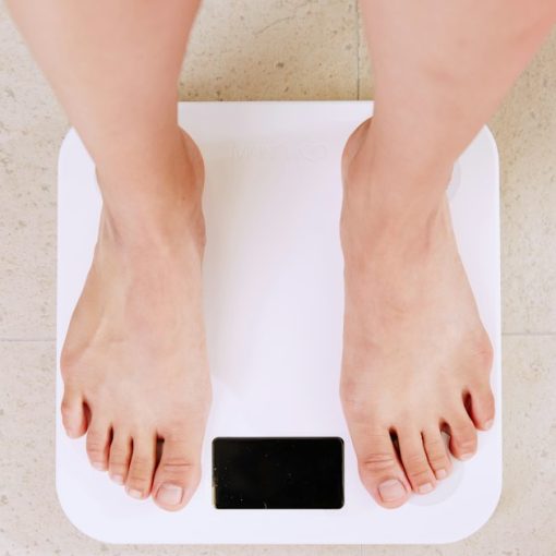 Person standing on white digital bathroom scale, illustrating the cloud is not a quick fix