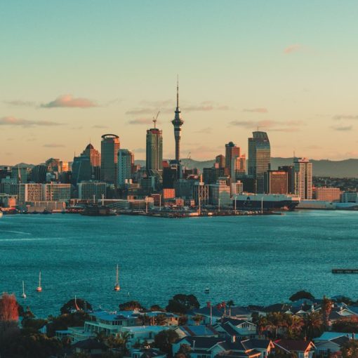 The Auckland skyline and harbor under a warm low sun in New Zealand, illustrating cloud adoption after the Christchurch quake