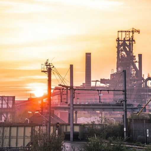 Industrial complex silhouetted against a bright sunset, illustrating client virtualization in the cloud