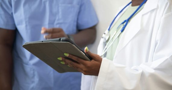 Doctor showing a patient information on a tablet, illustrating clientless VDI in healthcare