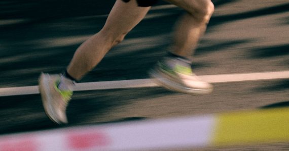 Runner's legs in motion on a track, illustrating the agility benefits of cloud computing