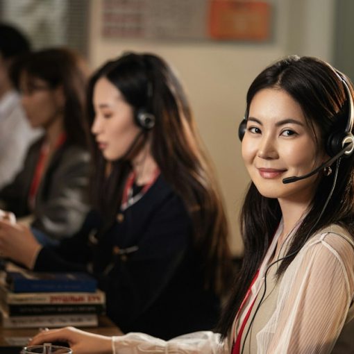 Smiling call center agent wearing a headset at a computer, illustrating a cloud call center