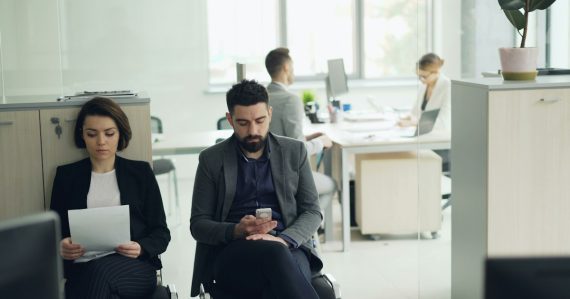 Two people waiting in an office lobby, illustrating how the cloud changes corporate IT