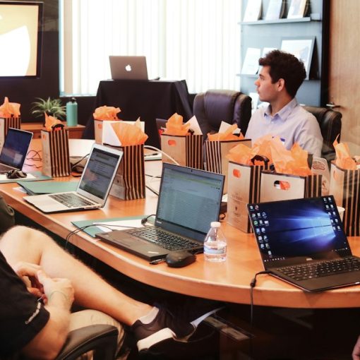 Man presenting to people seated at a table with laptops, illustrating defining cloud computing for the channel