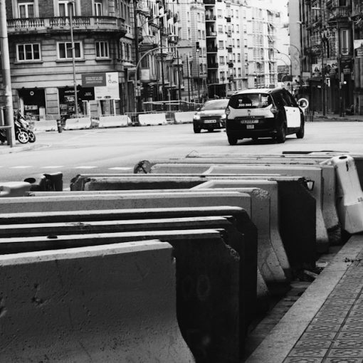 Concrete barriers line a city street with traffic, illustrating obstacles to cloud computing adoption