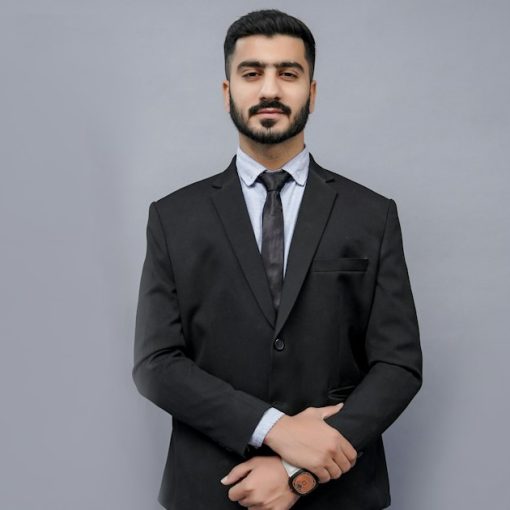 A man in a suit and tie posing for a picture, illustrating small business indecision on cloud benefits