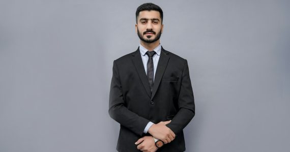 A man in a suit and tie posing for a picture, illustrating small business indecision on cloud benefits