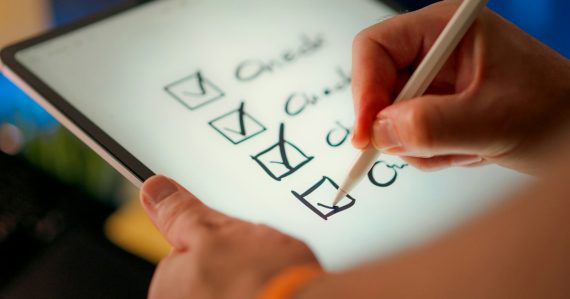 Hand ticking items off a checklist, illustrating whether your business is prepared for cloud computing