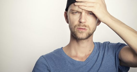 Confused man covering his face with his hand, illustrating small business confusion about cloud computing
