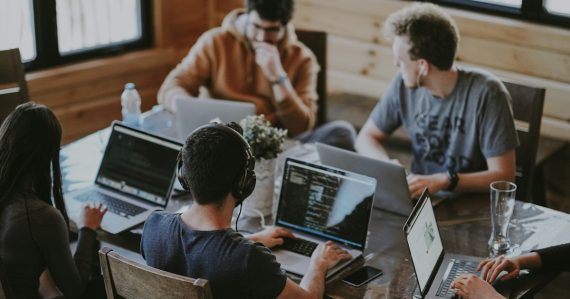 Group of people using laptop computer, illustrating ways cloud computing can help your business