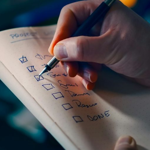 Hand checking off items on a to-do list, illustrating steps for successful cloud implementation