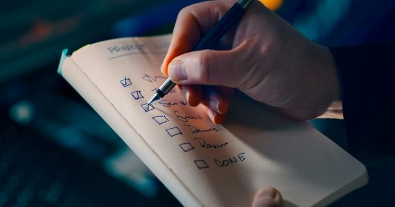 Hand checking off items on a to-do list, illustrating steps for successful cloud implementation