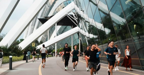 People jogging along a modern building's exterior path, illustrating business playing catch-up on cloud computing