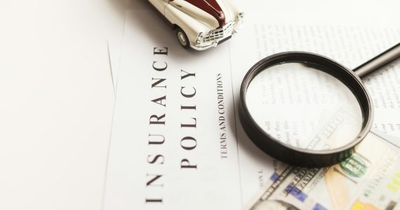 Magnifying glass on an insurance policy document, illustrating cloud computing in the insurance industry