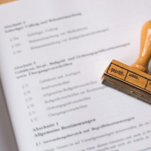 A wooden rubber stamp resting on an open legal document, illustrating legal issues in cloud computing