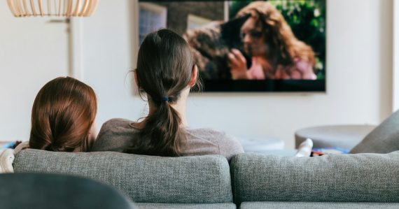 Two people on a couch watching a streaming show on TV, illustrating cloud computing in plain English