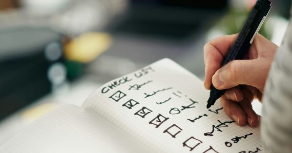 Someone is checking items off a checklist, illustrating keeping cloud projects compliant