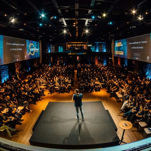 Speaker on stage addressing a large conference audience, illustrating how cloud computing requires IT to evolve