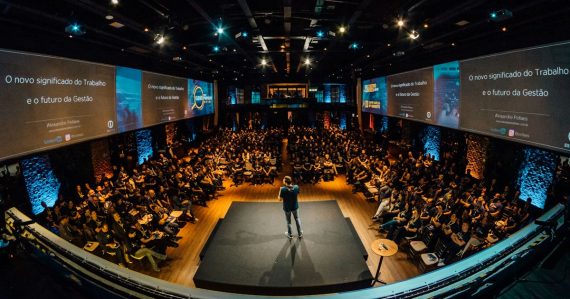 Speaker on stage addressing a large conference audience, illustrating how cloud computing requires IT to evolve