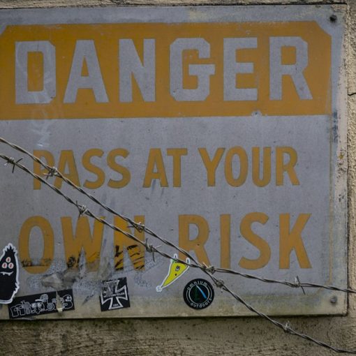 A sign on a wall that says danger pass at your own risk, illustrating the top risks of cloud computing