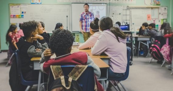 Students in classroom with teacher presenting, illustrating cloud computing for schools