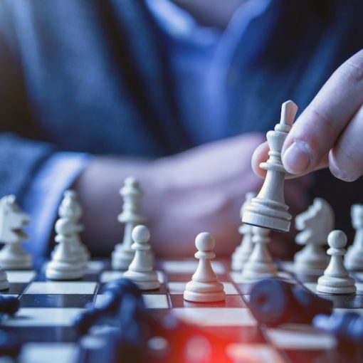 Man moving a chess piece on a chessboard, illustrating cloud computing strategies