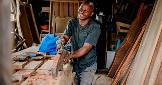 Smiling small business owner at work in his workshop, illustrating cloud computing tips for small businesses