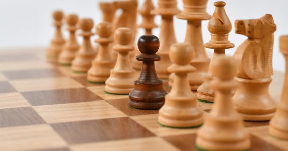 Selective focus photography of chess pieces, illustrating rising above the cloud computing war