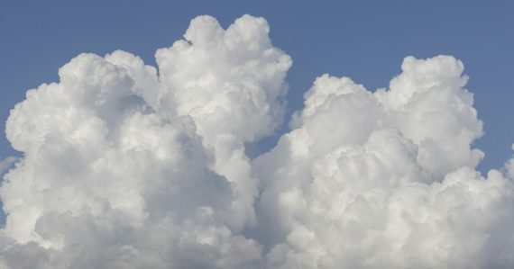 White clouds in a bright blue sky, illustrating a cloud-first strategy for business IT