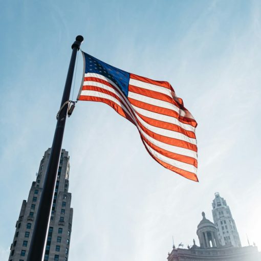 USA flag on pole in the city during day, illustrating cloud-friendly US cities