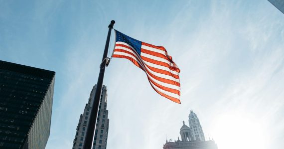 USA flag on pole in the city during day, illustrating cloud-friendly US cities