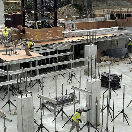 A group of men standing around a building under construction, illustrating companies ill-prepared for cloud goals