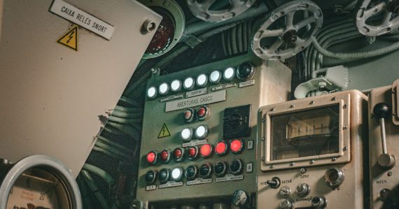 A submarine control panel full of buttons and dials, illustrating cloud governance over ownership
