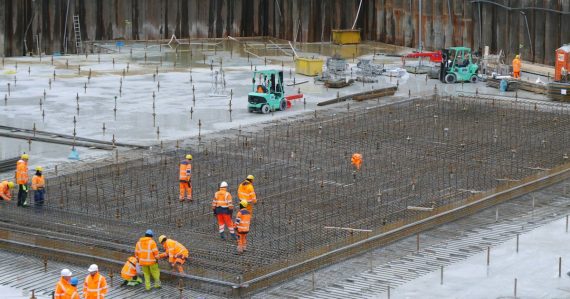 Construction workers standing around a building site, illustrating requirements for building cloud infrastructure