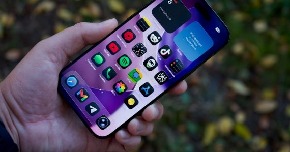 Hand holding a smartphone with colorful app icons, illustrating cloud computing's killer applications