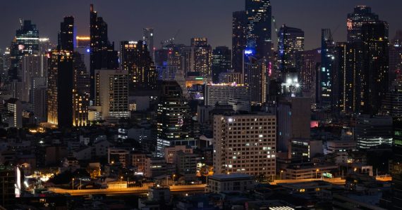 A city at night with a lot of tall buildings, illustrating clouds, mobility and security in Thailand